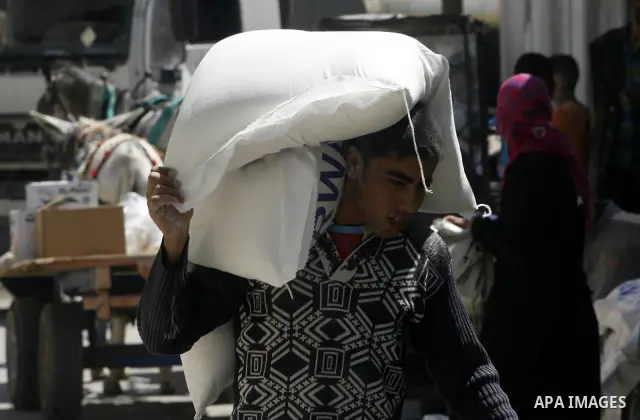 A Palestinian boy receives monthly food aid from the United Nations Relief and Works Agency (UNRWA) center in the Rafah refugee camp, southern Gaza on May 07, 2012. The UN Agency for Palestinian Refugees (UNRWA) in Gaza...