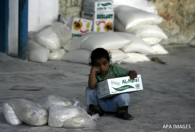 A Palestinian girl receives monthly food aid from the United Nations Relief and Works Agency (UNRWA) center in the Rafah refugee camp, southern Gaza on May 07, 2012. The UN Agency for Palestinian Refugees (UNRWA) in Gaza...