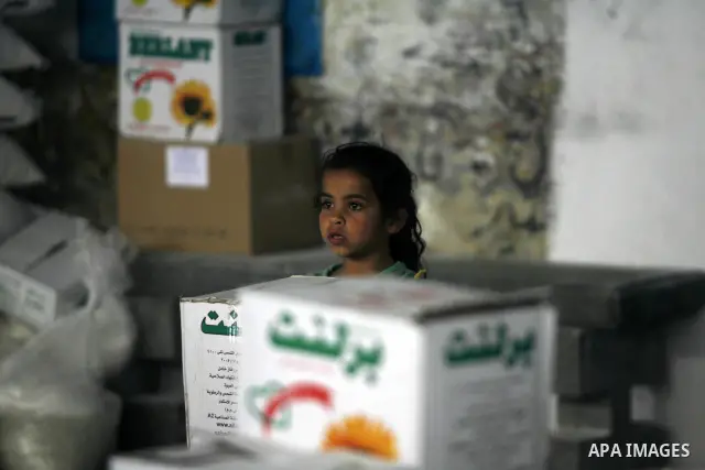 A Palestinian girl receives monthly food aid from the United Nations Relief and Works Agency (UNRWA) center in the Rafah refugee camp, southern Gaza on May 07, 2012. The UN Agency for Palestinian Refugees (UNRWA) in Gaza...
