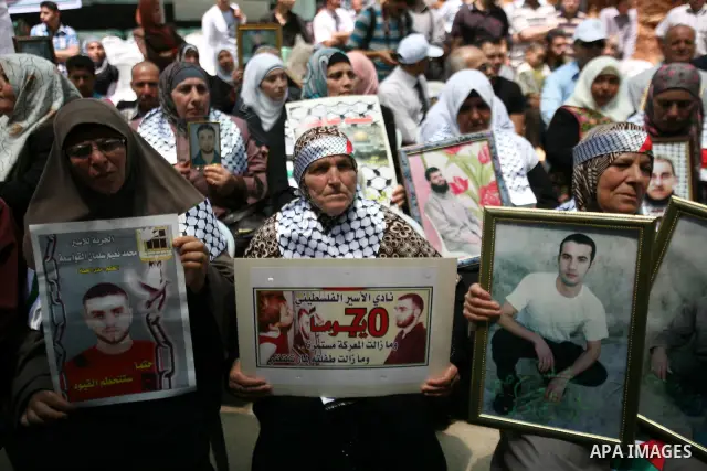 Palestinians participate in a rally supporting Palestinian inmates on hunger strike since mid-April 2012, in the West Bank City of Hebron, May 7, 2012. A Palestinian rights group said recently that half of about 5,000 Pa...