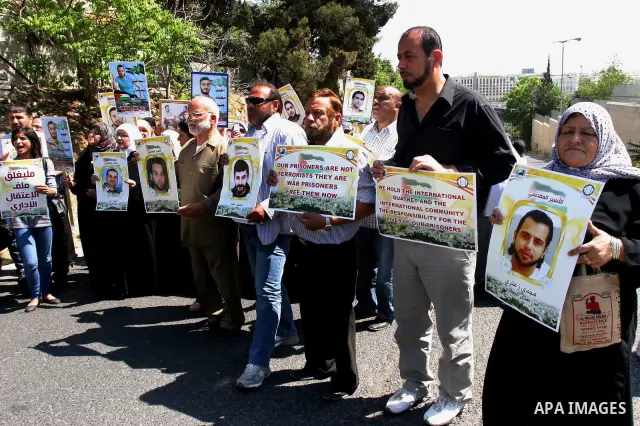 Palestinian protesters hold slogans and portraits of Palestinian prisoners, held in Israeli jails, during a demonstration in east Jerusalem on May 7, 2012 in solidarity with the prisoners. At least 1,550 imprisoned Pales...