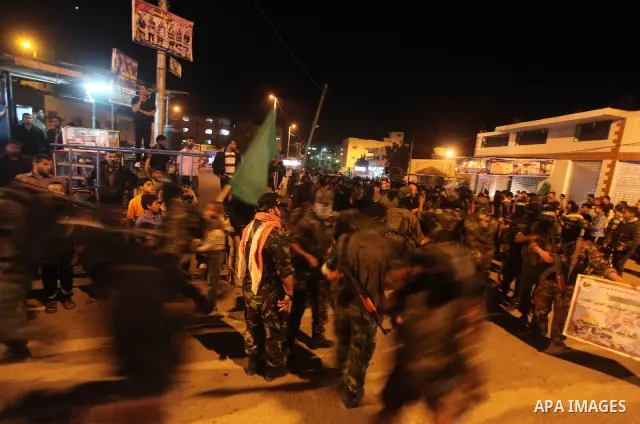 Masked Hamas militants march with their guns during a parade to show solidarity with Palestinian prisoners held in Israeli jails on May 7, 2012. At least 1,550 Palestinian prisoners are refusing food in Israeli jails in...