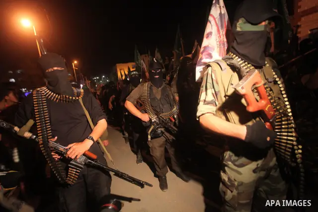 Masked Hamas militants march with their guns during a parade to show solidarity with Palestinian prisoners held in Israeli jails on May 7, 2012. At least 1,550 Palestinian prisoners are refusing food in Israeli jails in...
