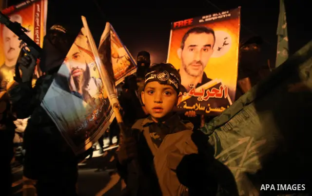 Masked Hamas militants march with their guns during a parade to show solidarity with Palestinian prisoners held in Israeli jails on May 7, 2012. At least 1,550 Palestinian prisoners are refusing food in Israeli jails in...