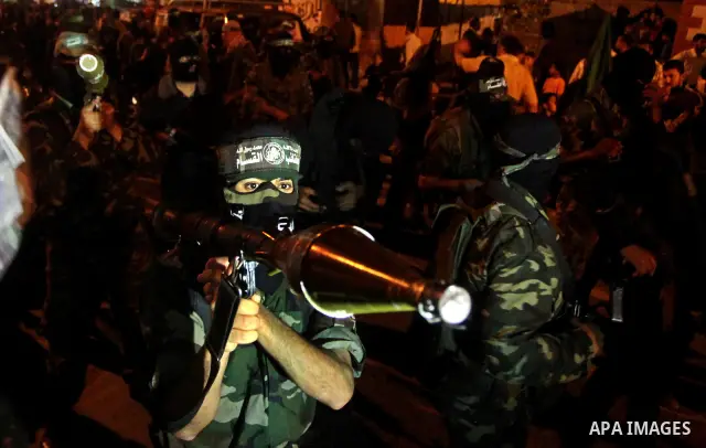 Masked Hamas militants march with their guns during a parade to show solidarity with Palestinian prisoners held in Israeli jails on May 7, 2012. At least 1,550 Palestinian prisoners are refusing food in Israeli jails in...