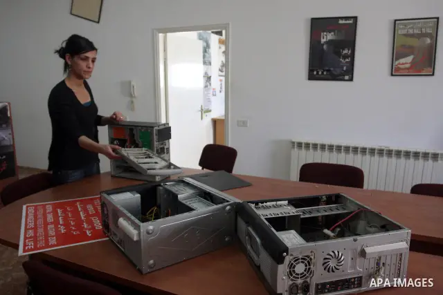 A Palestinian activist shows dismantled computers on May 8, 2012 at the offices of the Stop the Wall Campaign, a grassroots' movement overseeing the stuggle of the popoular committess in the West Bank against the controv...