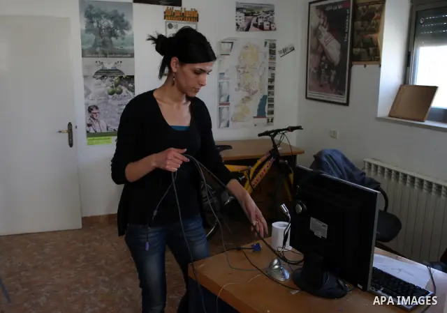 A Palestinian activist shows dismantled computers on May 8, 2012 at the offices of the Stop the Wall Campaign, a grassroots' movement overseeing the stuggle of the popoular committess in the West Bank against the controv...