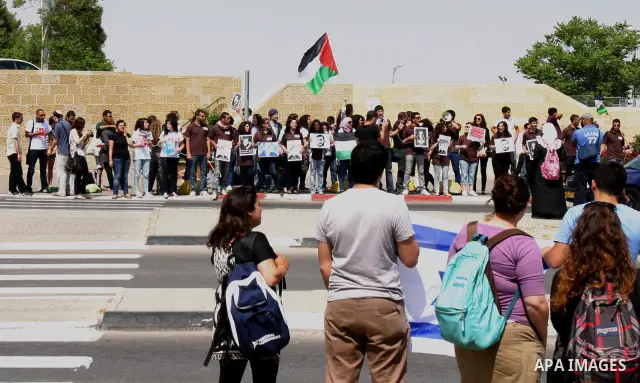Palestinian protesters hold slogans and portraits of Palestinian prisoners, held in Israeli jails, during a demonstration in east Jerusalem on May 8, 2012 in solidarity with the prisoners. At least 1,550 imprisoned Pales...