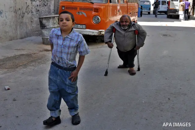 Marwan Abedah, a 58-year-old Palestinian refugee, and his son , leave their home in the alleys of the Askar refugee camp in the West Bank City of Nablus, 06 May 2012. The Abedah family, which has three handicapped relati...