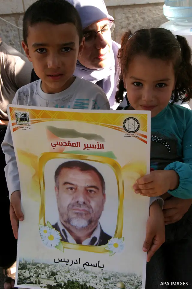 Palestinian children hold up portraits of Palestinian prisoners, held in Israeli jails, during a demonstration in front of the Red Cross center, east Jerusalem, on May 9, 2012 in solidarity with the prisoners. At least 1...