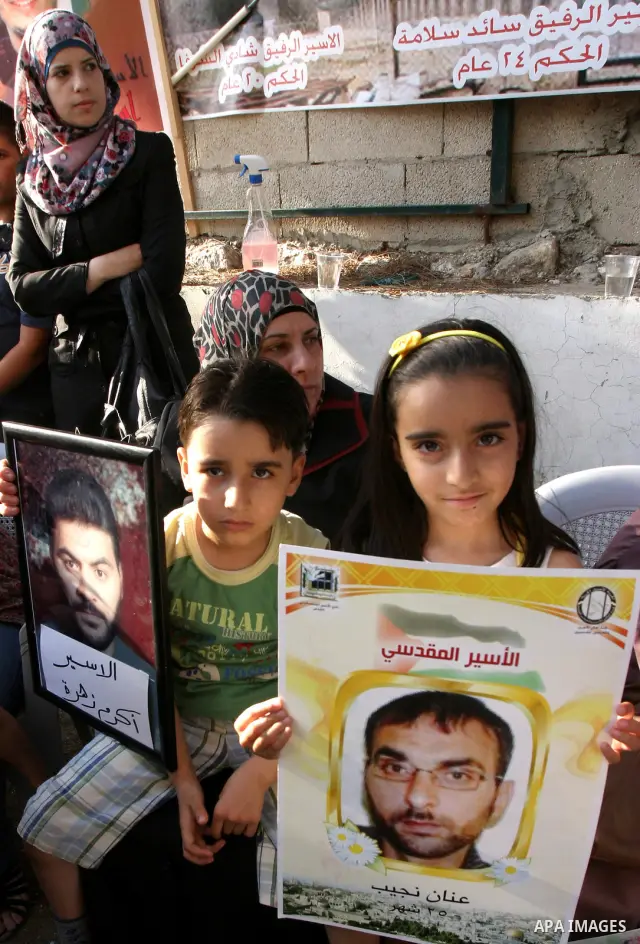 Palestinian children hold up portraits of Palestinian prisoners, held in Israeli jails, during a demonstration in front of the Red Cross center, east Jerusalem, on May 9, 2012 in solidarity with the prisoners. At least 1...