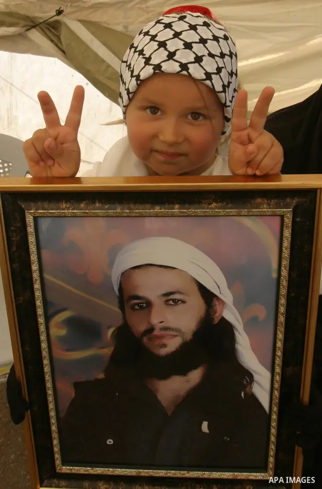 Palestinian child holds up portrait of Palestinian prisoner, held in Israeli jails, during a demonstration in front of the Red Cross center, east Jerusalem, on May 9, 2012 in solidarity with the prisoners. At least 1,550...