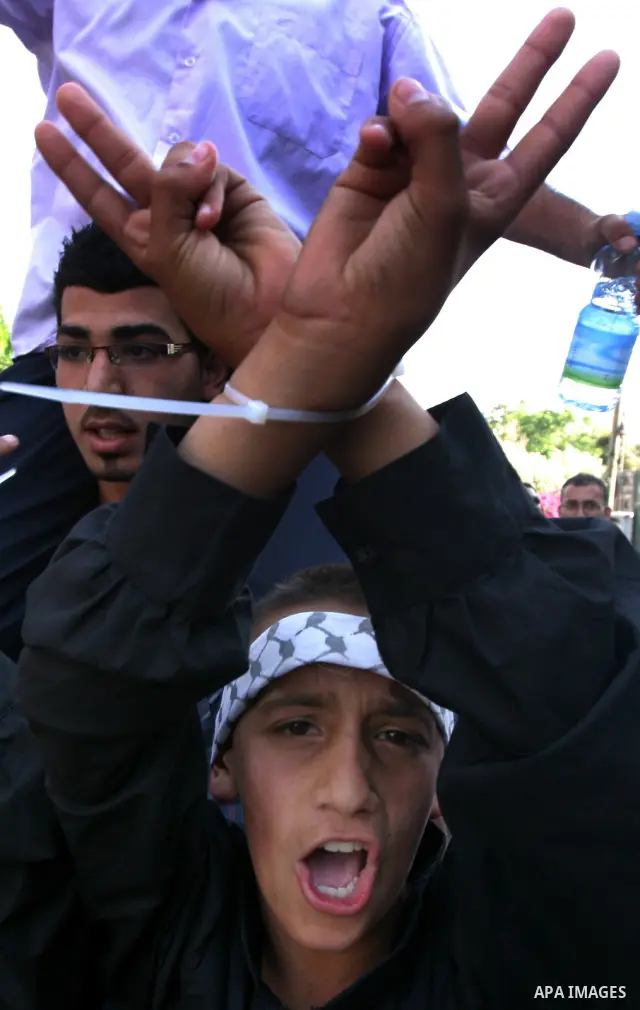 Palestinian protesters hold up portraits of Palestinian prisoners, held in Israeli jails, during a demonstration in front of the Red Cross center, east Jerusalem, on May 9, 2012 in solidarity with the prisoners. At least...