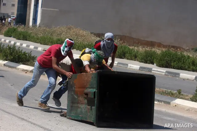 Palestinian protesters take part during a demonstration outside the Ofer Prison close to the West Bank city of Ramallah, in support of Palestinian prisoners on hunger strike in Israeli jails, on May 10, 2012. Israel's pr...