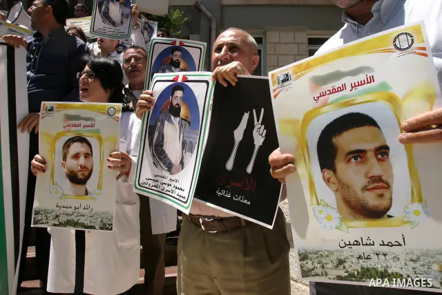 Palestinians hold portraits of their relatives held in Israeli jails during a protest in solidarity with prisoners on hunger strike, outside the European Union Representative Office in East Jerusalem May 10, 2012. Palest...