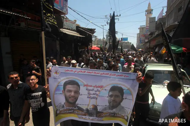 Palestinians hold up portraits of Palestinian prisoners, held in Israeli jails, and shout slogans during a demonstration in southern Gaza strip, city of Khan Younis, on May 11, 2012 in solidarity with the prisoners. At l...