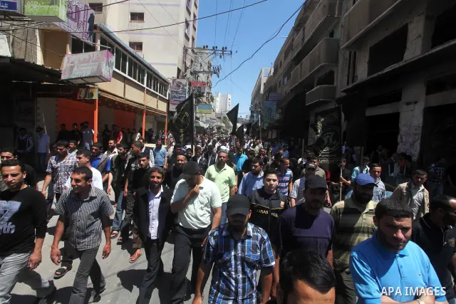 Palestinians hold up portraits of Palestinian prisoners, held in Israeli jails, and shout slogans during a demonstration in southern Gaza strip, city of Khan Younis, on May 11, 2012 in solidarity with the prisoners. At l...