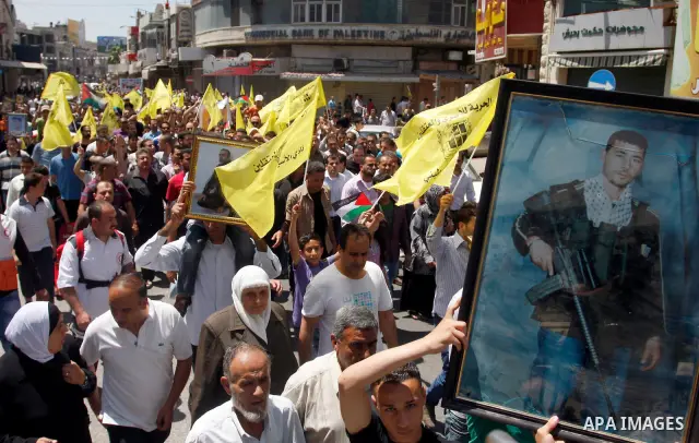 Palestinians participate a demonstration, and hold portraits of prisoners held in Israeli jails, following perform Friday prayers during a sit-in, in the West Bank city of Nablus, May 11, 2012. Palestinians held in praye...