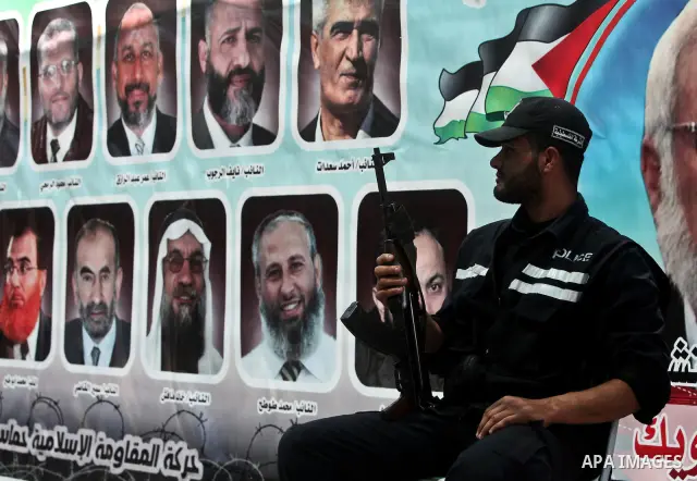 A Hamas policeman stands guard as Palestinians attend Friday prayers in Gaza City in support of more than a thousand prisoners who are on an open-ended hunger strike in Israeli jails on May 11, 2012. At least 1,550 Pales...