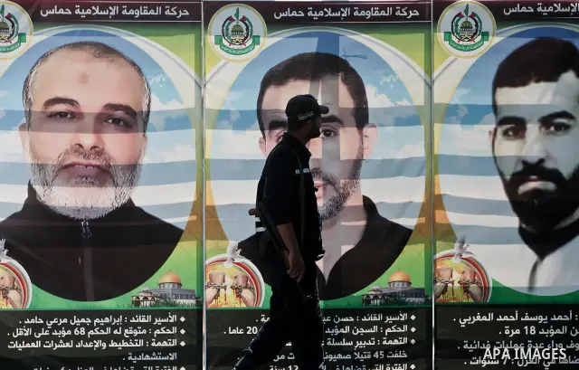 A Hamas policeman stands guard as Palestinians attend Friday prayers in Gaza City in support of more than a thousand prisoners who are on an open-ended hunger strike in Israeli jails on May 11, 2012. At least 1,550 Pales...