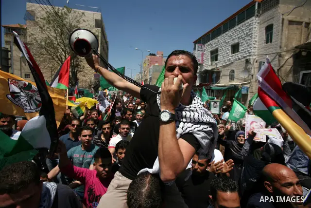 Palestinians participate a demonstration, and hold portraits of prisoners held in Israeli jails, solidarity with prisoners who have been waging a hunger strike in Israeli jails, on May 11, 2012, in the West Bank city of...