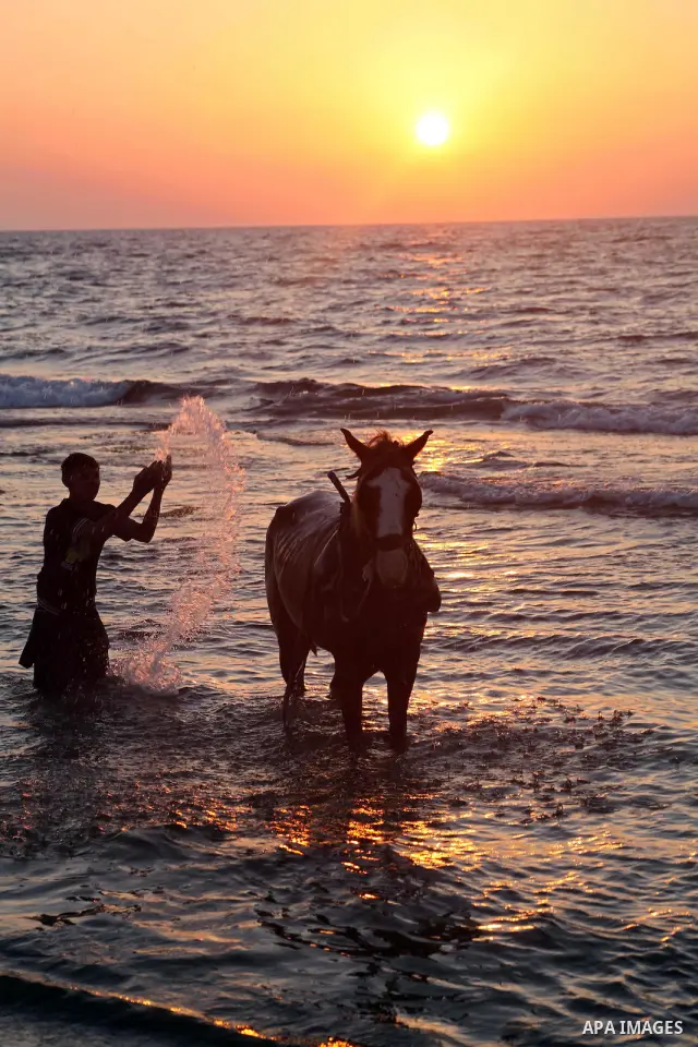 Palestinians enjoy a day on the beach of Khan Yunis, south of the Gaza Strip, on May 12, 2012. Photo by Ashraf Amra