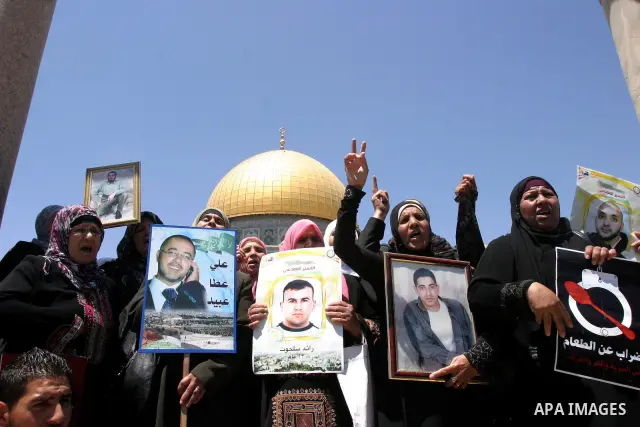 Palestinians hold portraits of relatives held in Israeli jails during a protest on the compound known to Muslims as Noble Sanctuary and to Jews as Temple Mount in Jerusalem's Old City, to show solidarity with prisoners o...