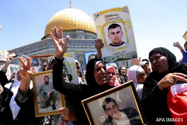 Palestinians hold portraits of relatives held in Israeli jails during a protest on the compound known to Muslims as Noble Sanctuary and to Jews as Temple Mount in Jerusalem's Old City, to show solidarity with prisoners o...