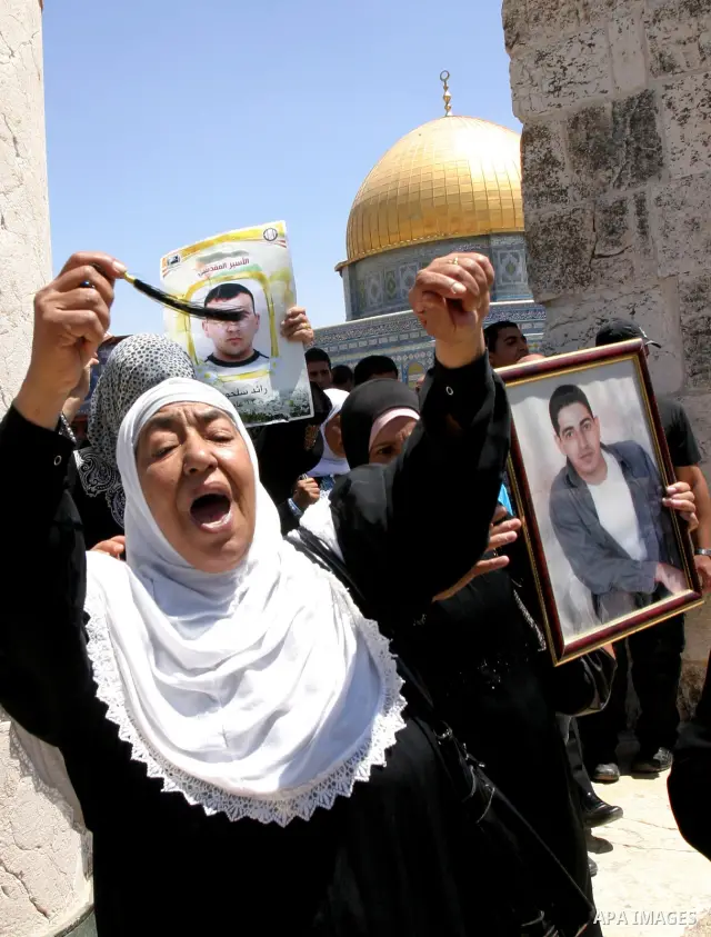 Palestinians hold portraits of relatives held in Israeli jails during a protest on the compound known to Muslims as Noble Sanctuary and to Jews as Temple Mount in Jerusalem's Old City, to show solidarity with prisoners o...