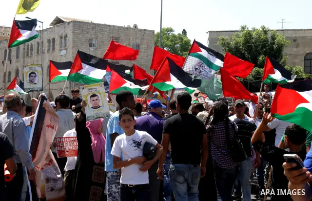 Palestinians hold portraits of relatives held in Israeli jails during a protest on the compound known to Muslims as Noble Sanctuary and to Jews as Temple Mount in Jerusalem's Old City, to show solidarity with prisoners o...