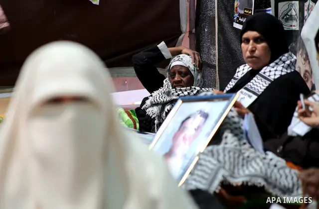 Palestinian women hold pictures of their jailed relatives during a sit-in in Gaza city in support of over 1,550 prisoners observing a hunger strike to demand better conditions in Israeli jails on May 12, 2012. The World...