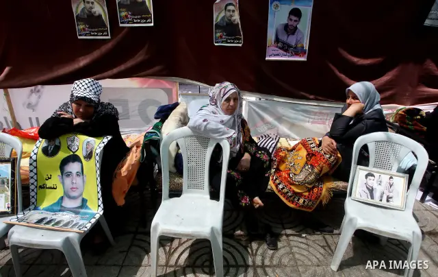 Palestinian women hold pictures of their jailed relatives during a sit-in in Gaza city in support of over 1,550 prisoners observing a hunger strike to demand better conditions in Israeli jails on May 12, 2012. The World...