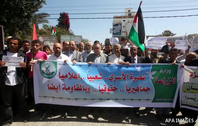 Palestinian women hold pictures of their jailed relatives during a sit-in in Gaza city in support of over 1,550 prisoners observing a hunger strike to demand better conditions in Israeli jails on May 12, 2012. The World...