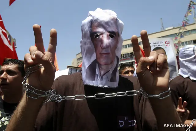 Palestinian protesters cover their faces with pictures of Palestinian prisoners during protests in the center of Nablus City , 12 May 2012 for the release of prisoners held in Israeli jails. Hundreds of Palestinians serv...