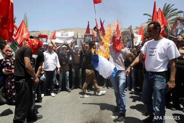 Palestinian protesters cover their faces with pictures of Palestinian prisoners during protests in the center of Nablus City , 12 May 2012 for the release of prisoners held in Israeli jails. Hundreds of Palestinians serv...