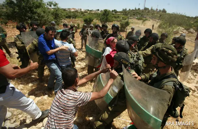 Palestinian protesters and foreign activists scuffle with Israeli soldiers during a demonstration ahead of "Nakba Day" in Beit Omar village, north of the West Bank town of Hebron, on May 12, 2012 where Israeli soldiers t...