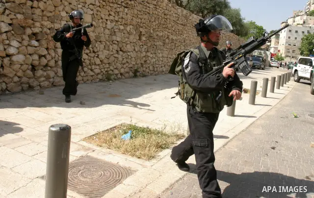 Israeli riot police fire teargas, before arresting a Palestinian during clashes between Palestinian youth and the Israeli police in the east Jerusalem neighbourhood of Silwan on May 12, 2012. Israel is to reply on May 12...