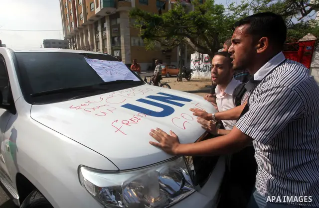 A Palestinian youth writes on the plaque of the Office of the United Nations Special Coordinator (UNSCO) headquarters in Gaza, as they forced the offices to close for two hours in solidarity with over 1,550 prisoners obs...