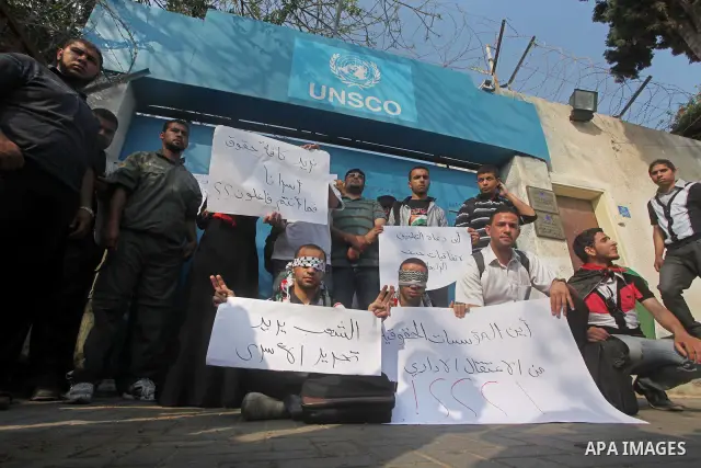Palestinian men stand outside the headquarters of the International Committee of the Red Cross (ICRC) in Gaza as they forced the offices to close for two hours in solidarity with over 1,550 prisoners observing a hunger s...
