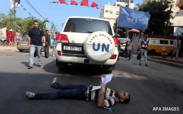 A Palestinian protestor lies on the ground during a protest in front of the Red Cross headquarters in Gaza City to show solidarity with Palestinian prisoners held in Israeli jails May 13, 2012. Hundreds of Palestinians o...