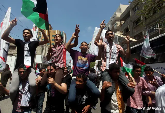 Palestinian protesters hold up signs outside the headquarters of the International Committee of the Red Cross (ICRC) during a protest in Gaza City, to show solidarity with Palestinian prisoners held in Israeli jails, May...