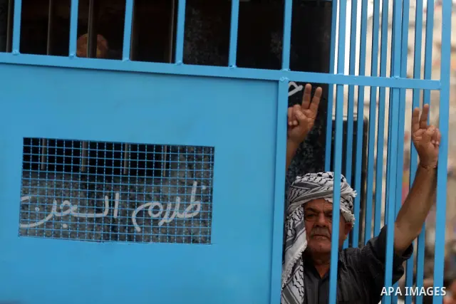 A Palestinian man gestures from inside a mock prison cell during a rally in the West Bank city of Ramallah, in support of Palestinian prisoners on a hunger strike in Israeli jails May 14, 2012. One in three of the 4,800...