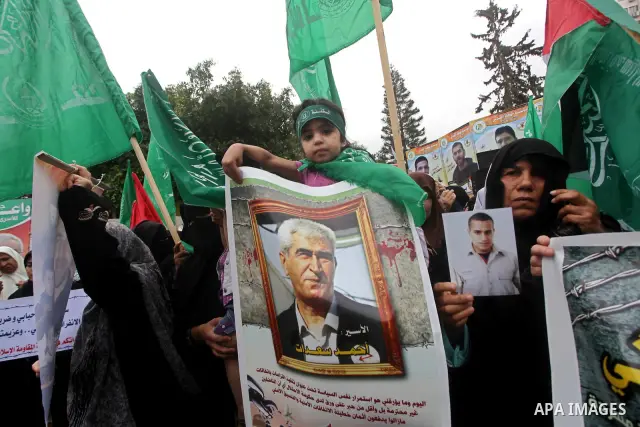 Palestinian women hold pictures of incarcerated relatives in a rally to show solidarity with prisoners held in Israeli jails, in Gaza City May 14, 2012. One in three of the 4,800 Palestinians serving time in Israeli jail...