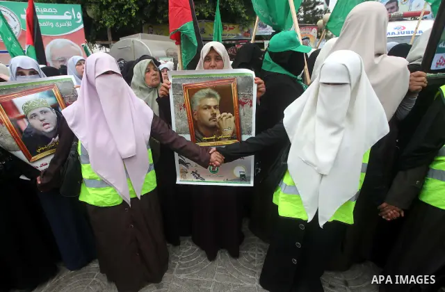 Palestinian women hold pictures of incarcerated relatives in a rally to show solidarity with prisoners held in Israeli jails, in Gaza City May 14, 2012. One in three of the 4,800 Palestinians serving time in Israeli jail...