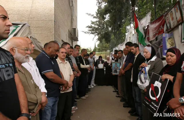 Palestinian protesters hold pictures of Palestinian prisoners during a visit to a protest tent outside the International Committee of the Red Cross (ICRC) offices in East Jerusalem, as the protestors join the hunger stri...