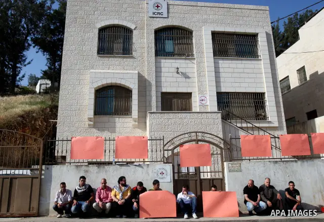 Palestinians attached a banners outside the headquarters of the International Committee of the Red Cross (ICRC) in the West Bank City of Nablus, 14 May 2012, as they forced the offices to close for three hours in solidar...