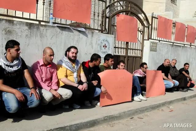Palestinians attached a banners outside the headquarters of the International Committee of the Red Cross (ICRC) in the West Bank City of Nablus, 14 May 2012, as they forced the offices to close for three hours in solidar...