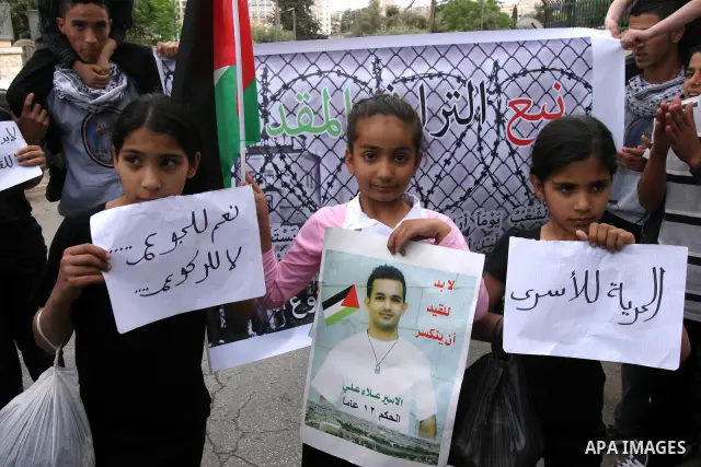 Palestinian children hold pictures and portraits of their relatives held in Israeli jails during a protest in solidarity with prisoners on hunger strike, in Jerusalem, May 10, 2012. Photo by Mahfouz Abu Turk