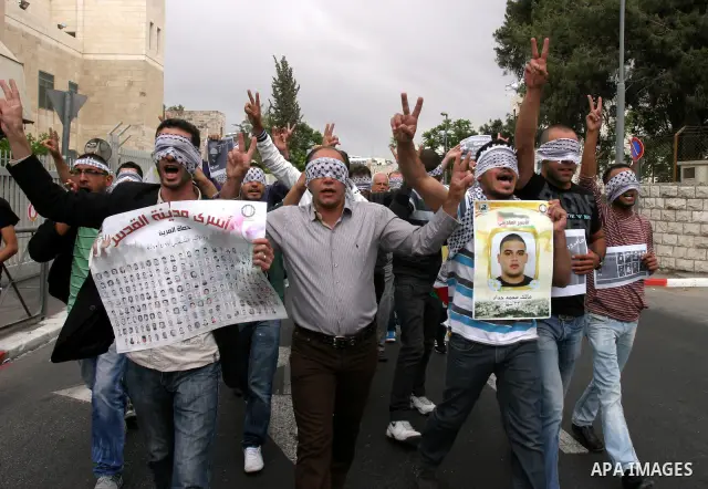 Palestinians hold pictures and portraits of their relatives held in Israeli jails during a protest in solidarity with prisoners on hunger strike, in Jerusalem, May 10, 2012. Photo by Mahfouz Abu Turk