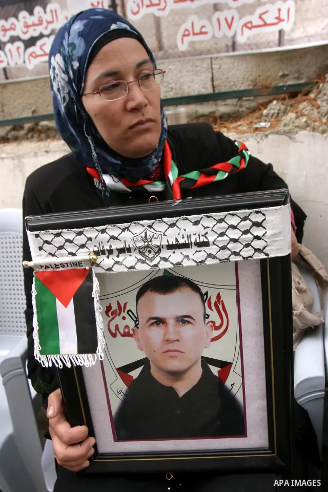 Palestinian woman holds portrait of herrelative held in Israeli jails during a protest in solidarity with prisoners on hunger strike, in Jerusalem, May 10, 2012. Photo by Mahfouz Abu Turk